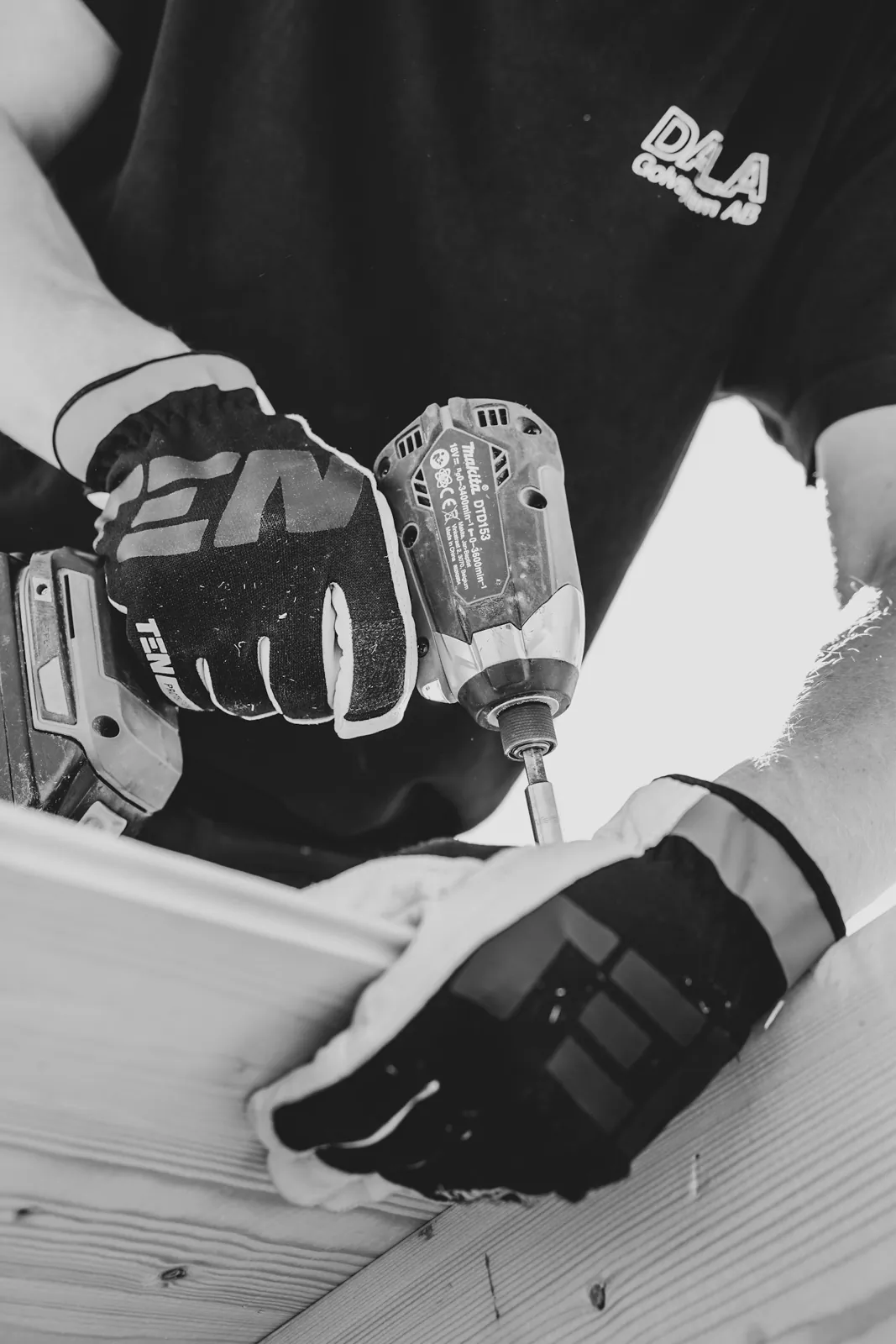A tradesperson using a drill on timber